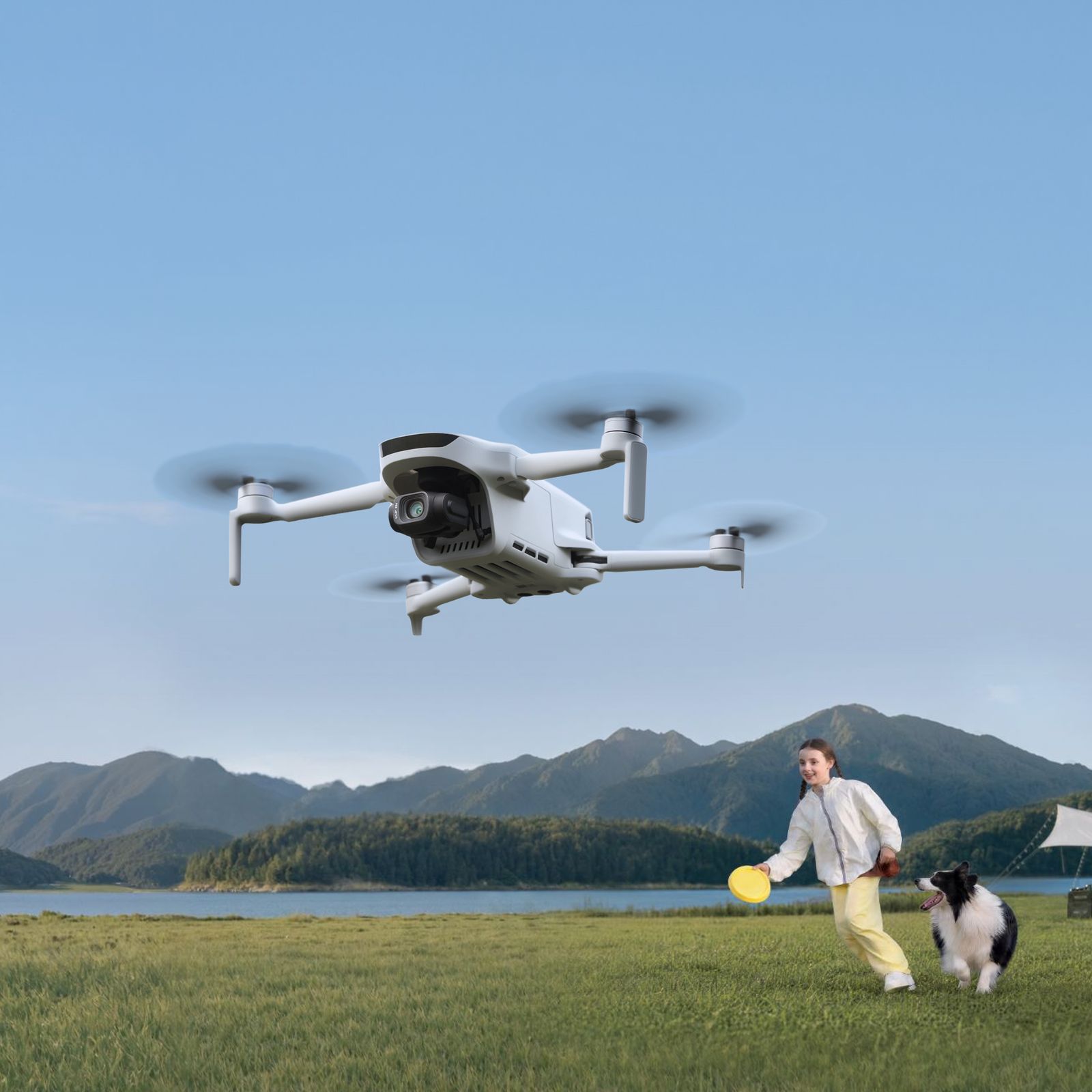 Dete i pas igraju se frizbijem dok iznad njih leti consumer dron