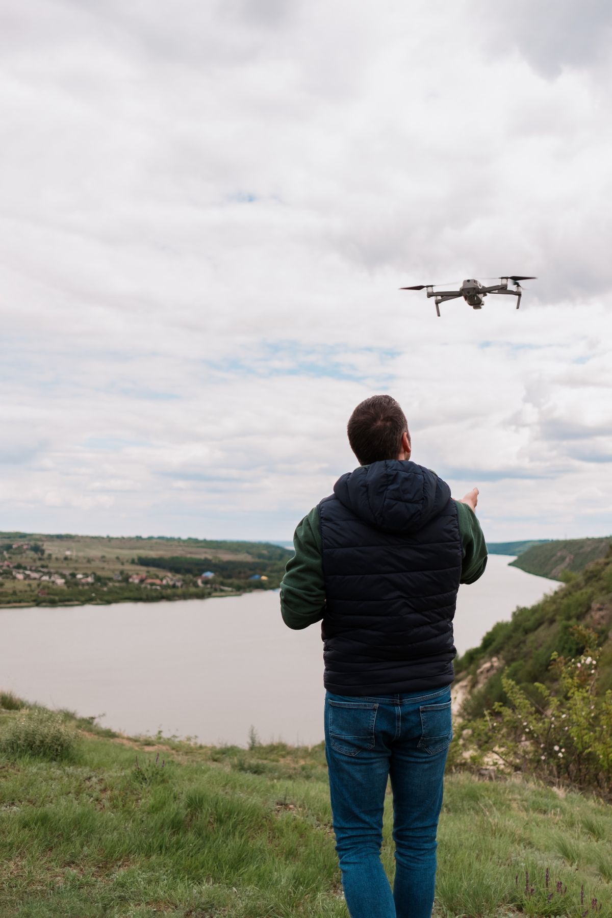 Pilot lansira dron iznad rečne doline